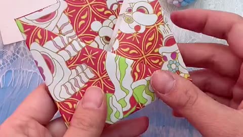 Hands Folding Traditional Red and Gold Cloud Patterned Paper