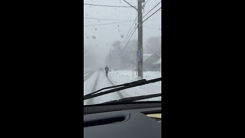 Crazy guy on scooter riding in a snowstorm!