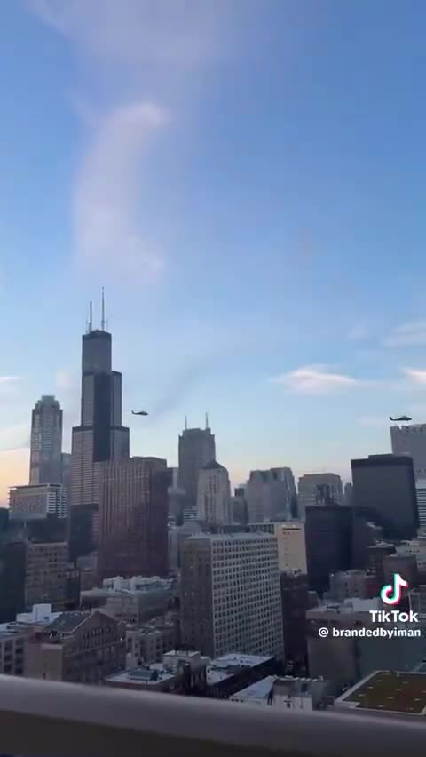 US military BLACKHAWK helicopters are flying over the city of Chicago