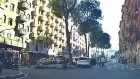 A rider crosses an intersection in Rome when the traffic light is red.