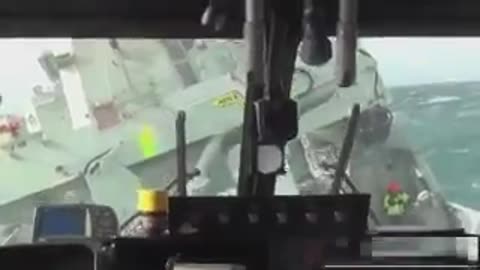 Lynx Helicopter landing on ship in rough seas.