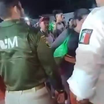 Mexican Immigration and Military officials stand by while a caravan walks through