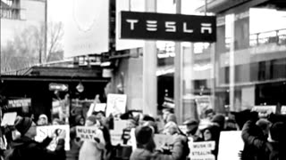 People protesting outside outside of a tesla building