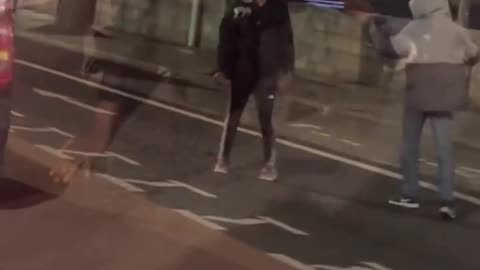 Dublin African fighting in the streets while a Brazilian records and commentates on the fight.