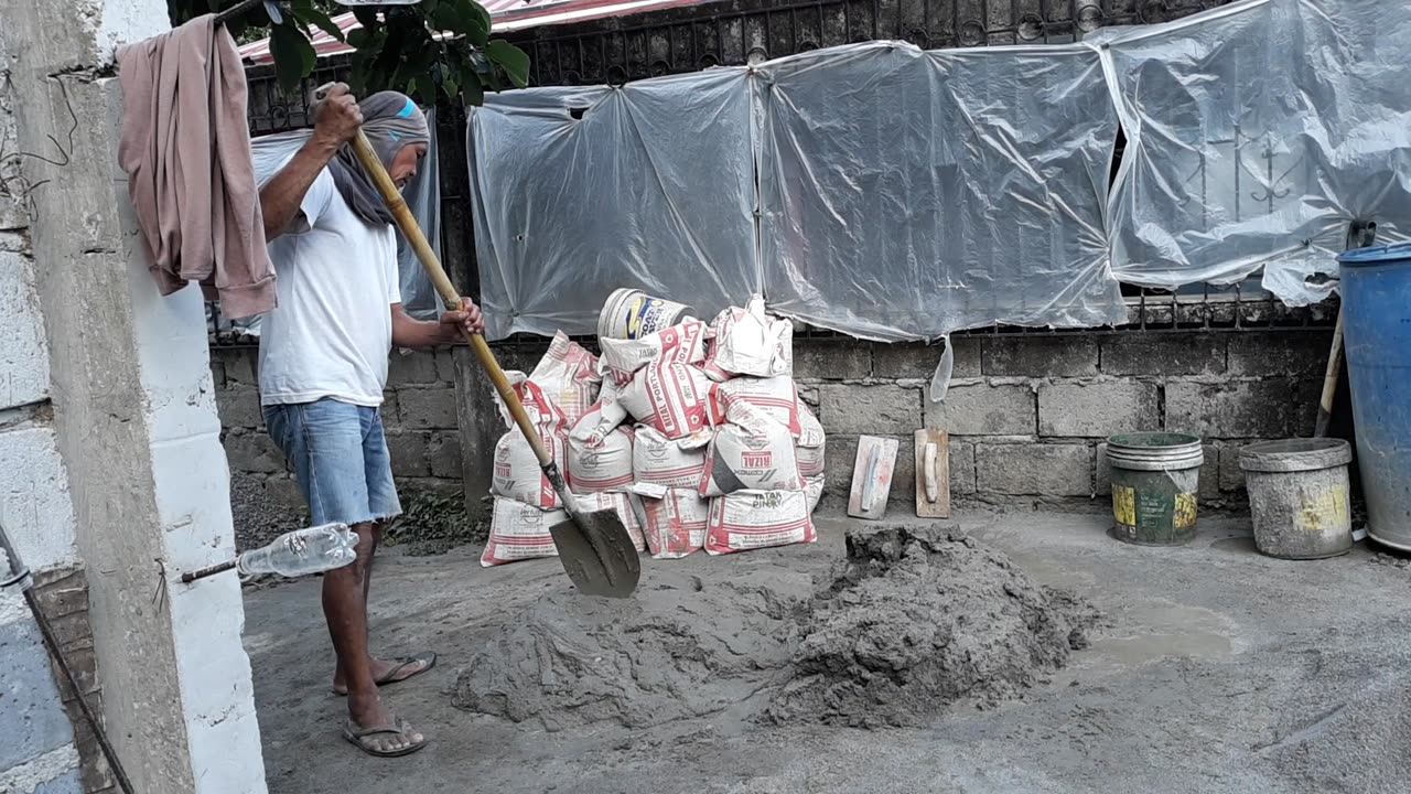 Mixing sifted sand and cement to smooth the walls.