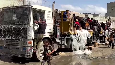 Palestinians crowd around aid trucks in Gaza's Khan Younis