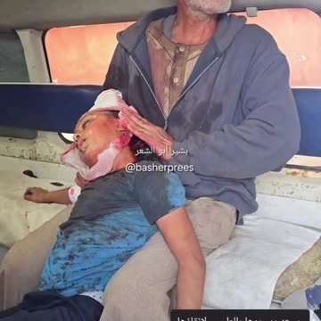 Palestinian grandfather carries his 10 year old granddaughter to hospital