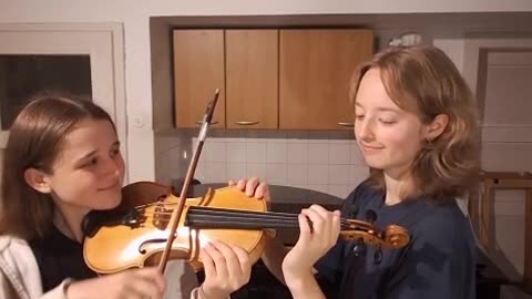 2 Girls Play 1 Violin While A Guy Plays Piano Laying on His Back