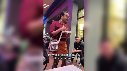 A man dressed as a woman scolds a woman dressed as an Indian for Halloween