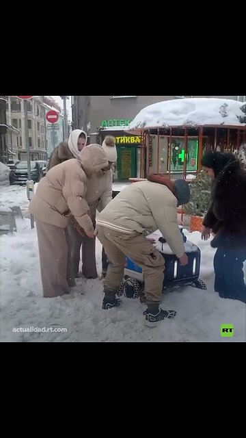 Transeúntes ayudan a un robot repartidor atascado en la nieve