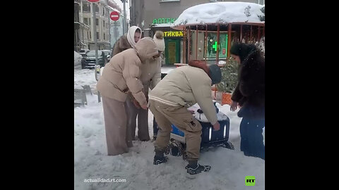 Transeúntes ayudan a un robot repartidor atascado en la nieve