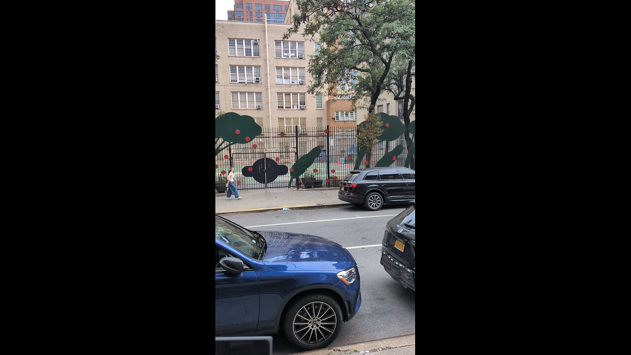 Air conditioners in windows above a playground in New York City.