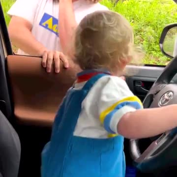 Dad pretends son is driving the truck. Kid's laugh is great!