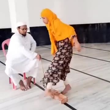 Islamic preacher educates little girls with a stick.