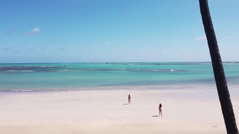 A couple running towards the sea