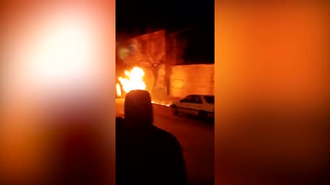 Fires burn as protesters gather outside police station in Iran
