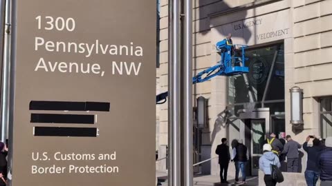 Signs outside US Agency for International Development being removed and taped over.