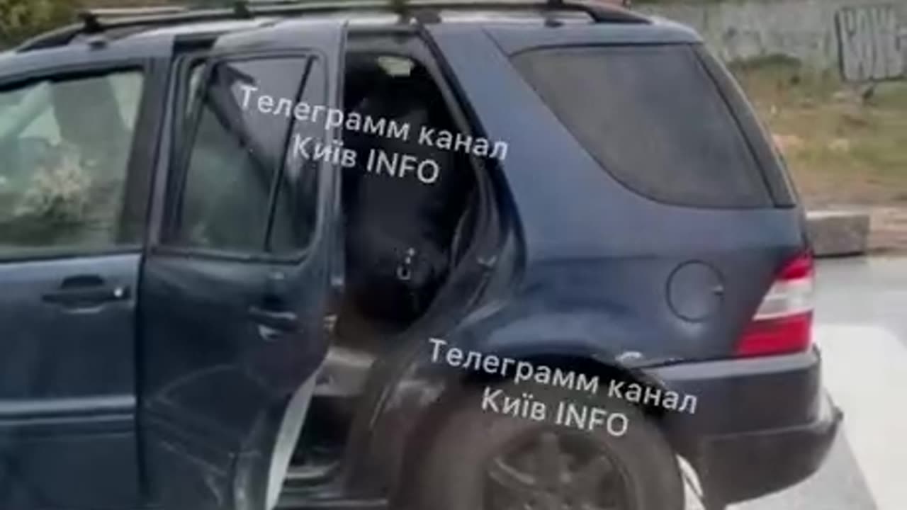 In Kiev, police officers are pushing and kicking a conscript into a car