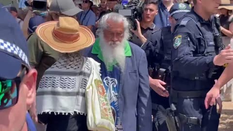 A woman in a kaffiyeh has been escorted by police away from the Bondi Pavilion