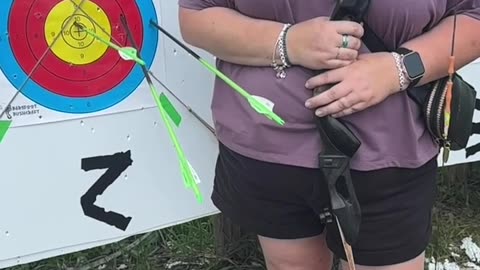 🏹 Barefoot and focused — she draws her recurve bow and releases in slow motion.