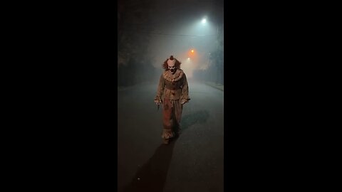 Scary clown comes out of the fog with a knife
