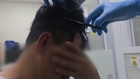 Colombian police catch a man smuggling packets of cocaine under toupee