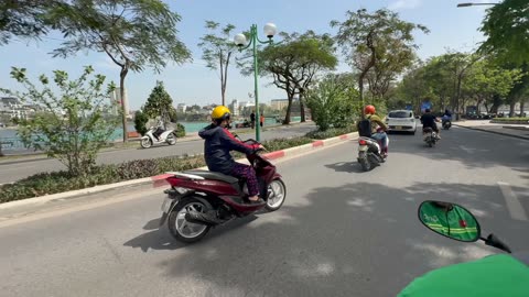Riding on the back of a scooter in Hanoi, Vietnam