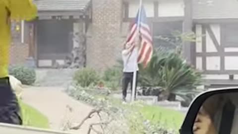 Man rescues American flag from stranger's yard as home burns behind him