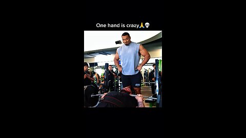 Baker bench pressing one hand with Larry Wheels