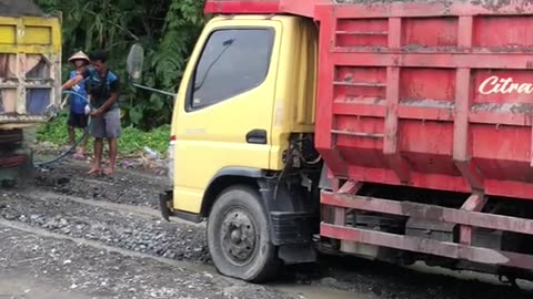 queue of trucks being loaded with sand