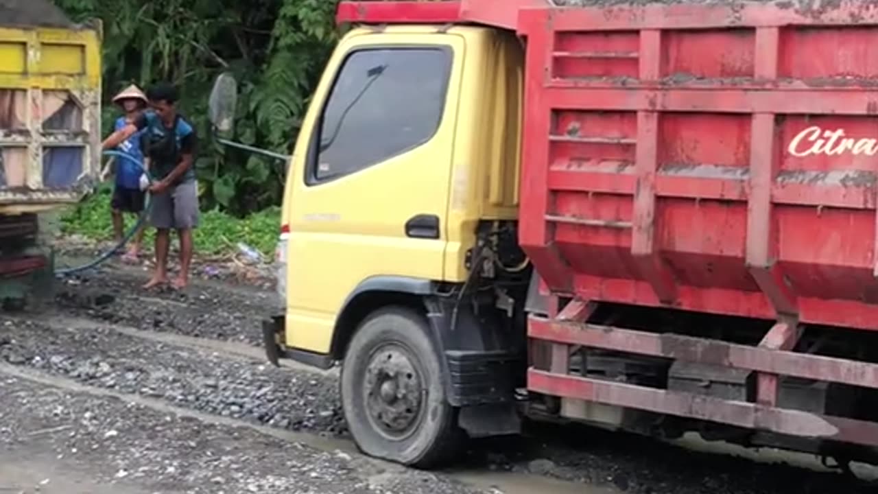 queue of trucks being loaded with sand