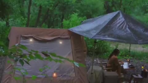 Pretty girl camping in heavy rain in the forest