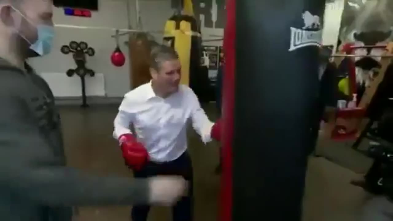 Keir Starmer trying to punch a punching bag.