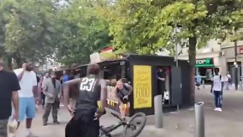 Watch as a migrant kicks a man riding his bike for no reason and UK officers aid in his escape.