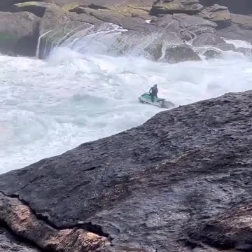 Jet ski person saves a surfer in colossal waves.
