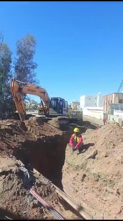 Excavator operator working in road working pip line