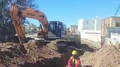 Excavator operator working in road working pip line