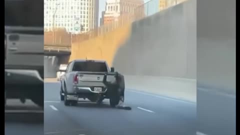 Man Hangs On to Moving Pickup Truck