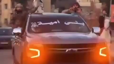 Islamists in cars and on horseback, waving Al-Qaeda flags