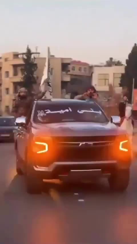 Islamists in cars and on horseback, waving Al-Qaeda flags
