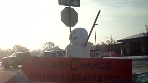 Snowman holding the sign for a last chance building and crafts supply store