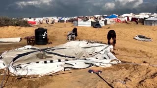 Displaced Palestinians fix their tents after night of heavy wind, rain