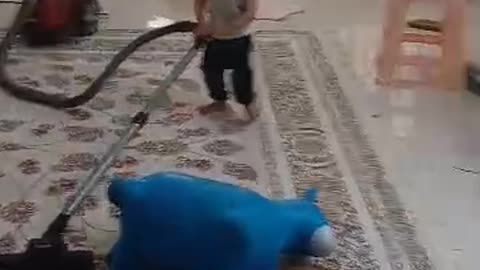Radmehr, a cute one-year-old boy vacuuming