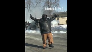 Big Black Protestor in Minneapolis laughs as he swaggers down the street, giving the finger