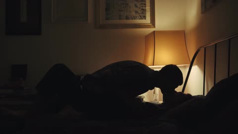 Side View of a Couple Kissing at Bed