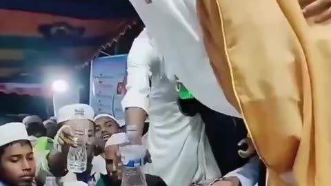 The Islamic imam blesses water with his spit, then faithful drink it with gusto.