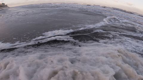 Waves washing over a shoreline blanketed in sea foam. Just soaking in the calm. #outdoorcuriosity