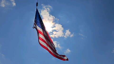 Amer8can Flag infront of sun during race day at Maple Grove Raceway