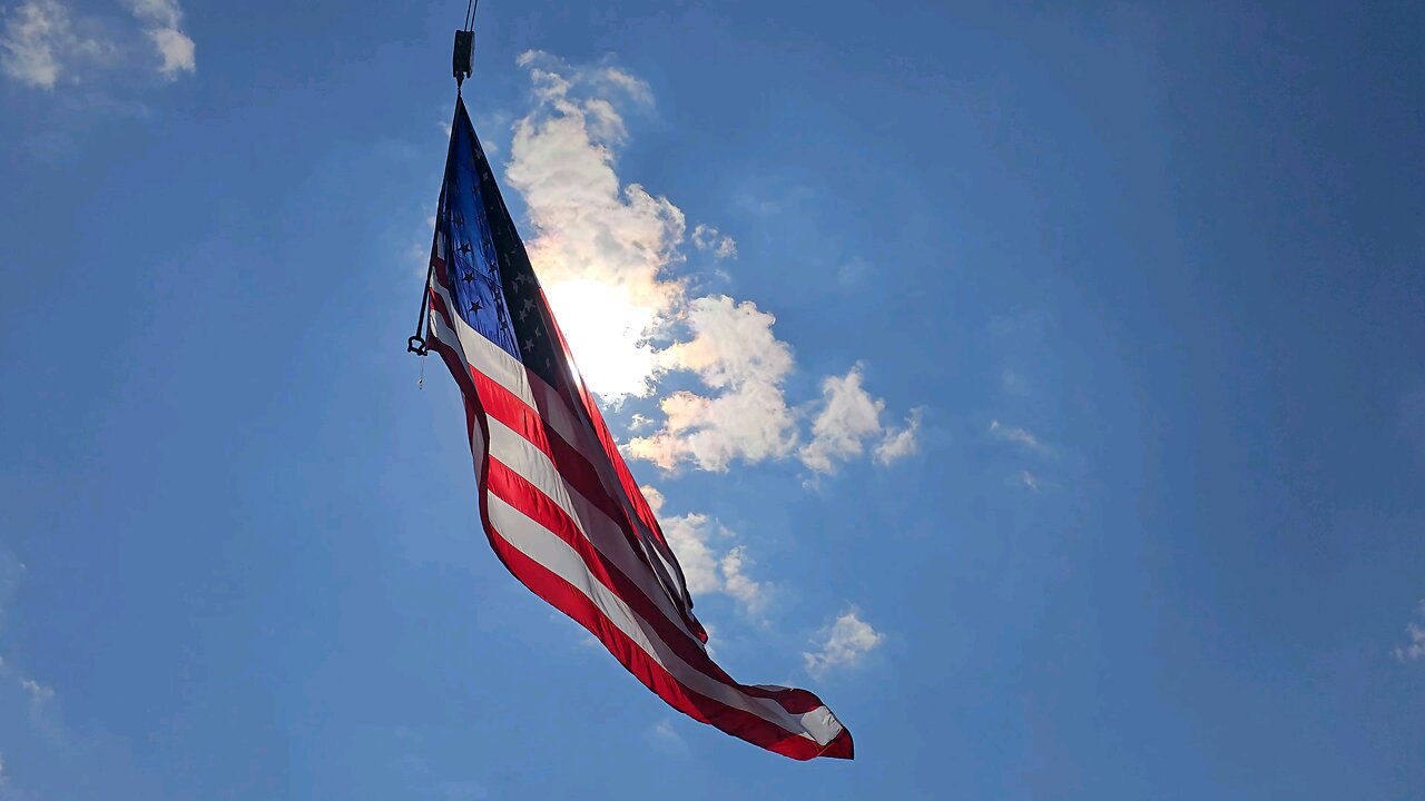 Amer8can Flag infront of sun during race day at Maple Grove Raceway