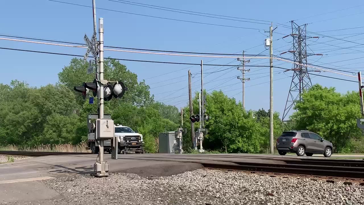 CSX Highrailer patiently waits for traffic and a bus to cross